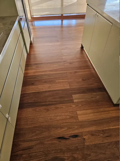 Hardwood floor running the length of a galley kitchen