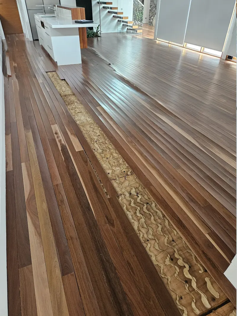 Before: a strip of floorboards lifted, exposing the subfloor