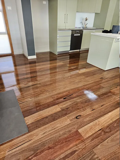 Glossy hardwood floorboards in an open-plan kitchen