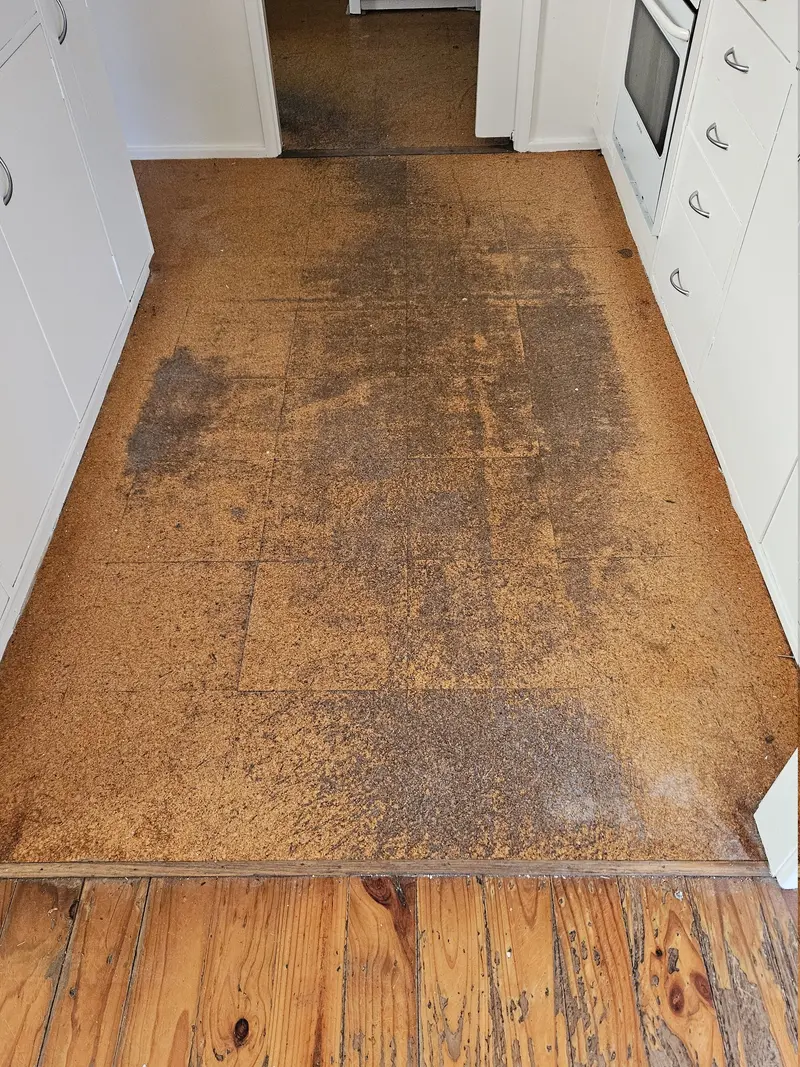 Before: worn, discoloured cork tiles in a kitchen